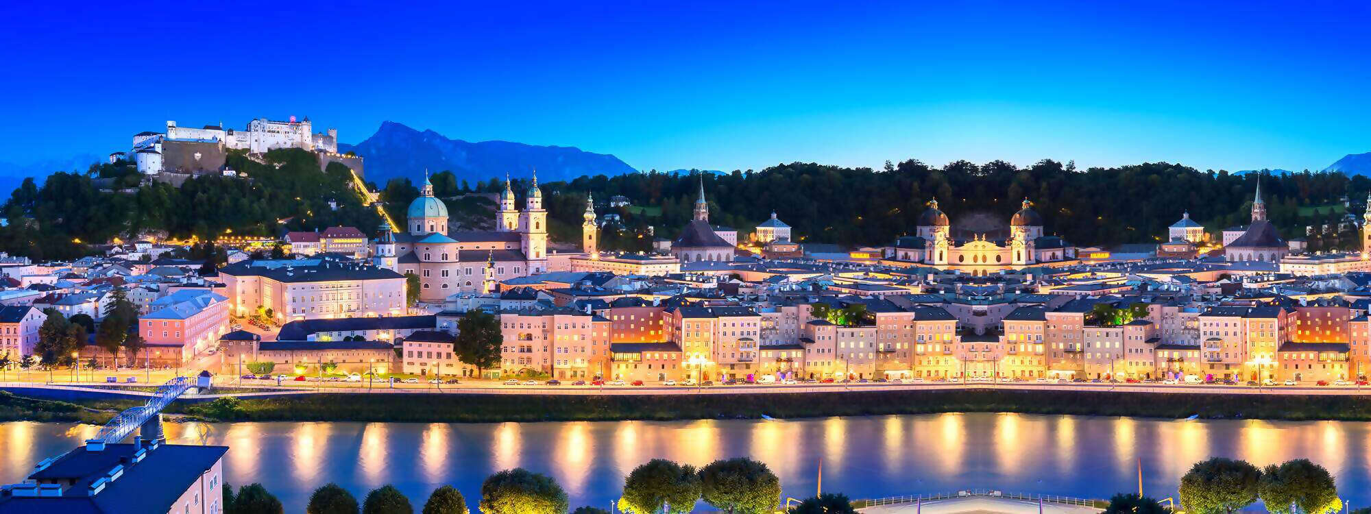 Die Stadt Salzburg am Abend mit der Festung Hohen Salzburg im Hintergrund